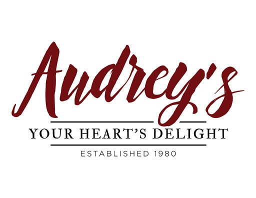 A red and white logo of audrey 's