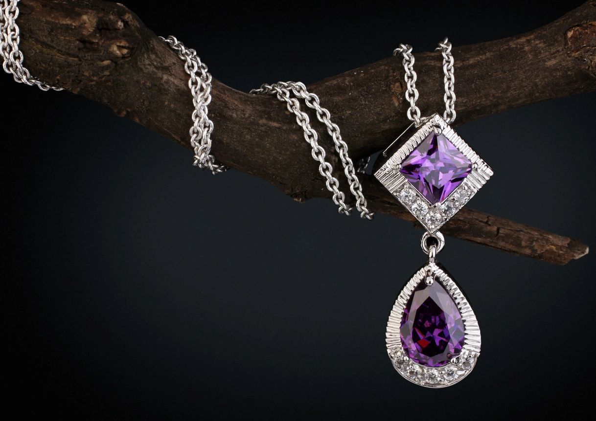 fm=f_D1JQJZQ A necklace with a purple stone hanging from it.